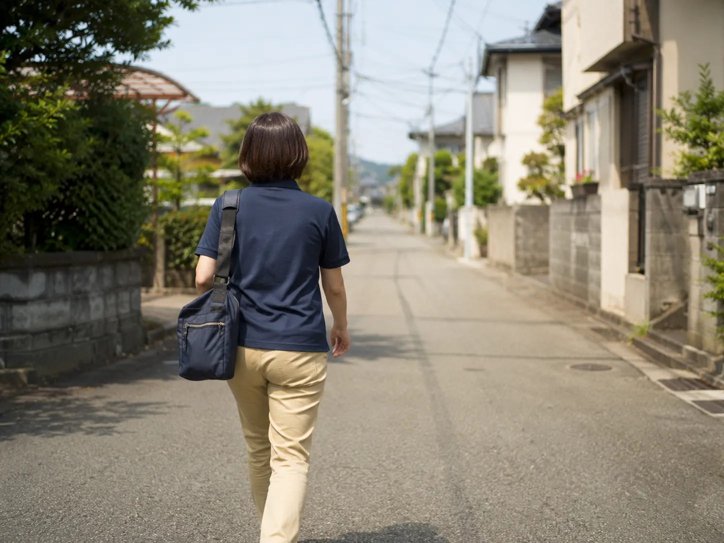 一人で訪問先へ向かう看護師の後ろ姿
