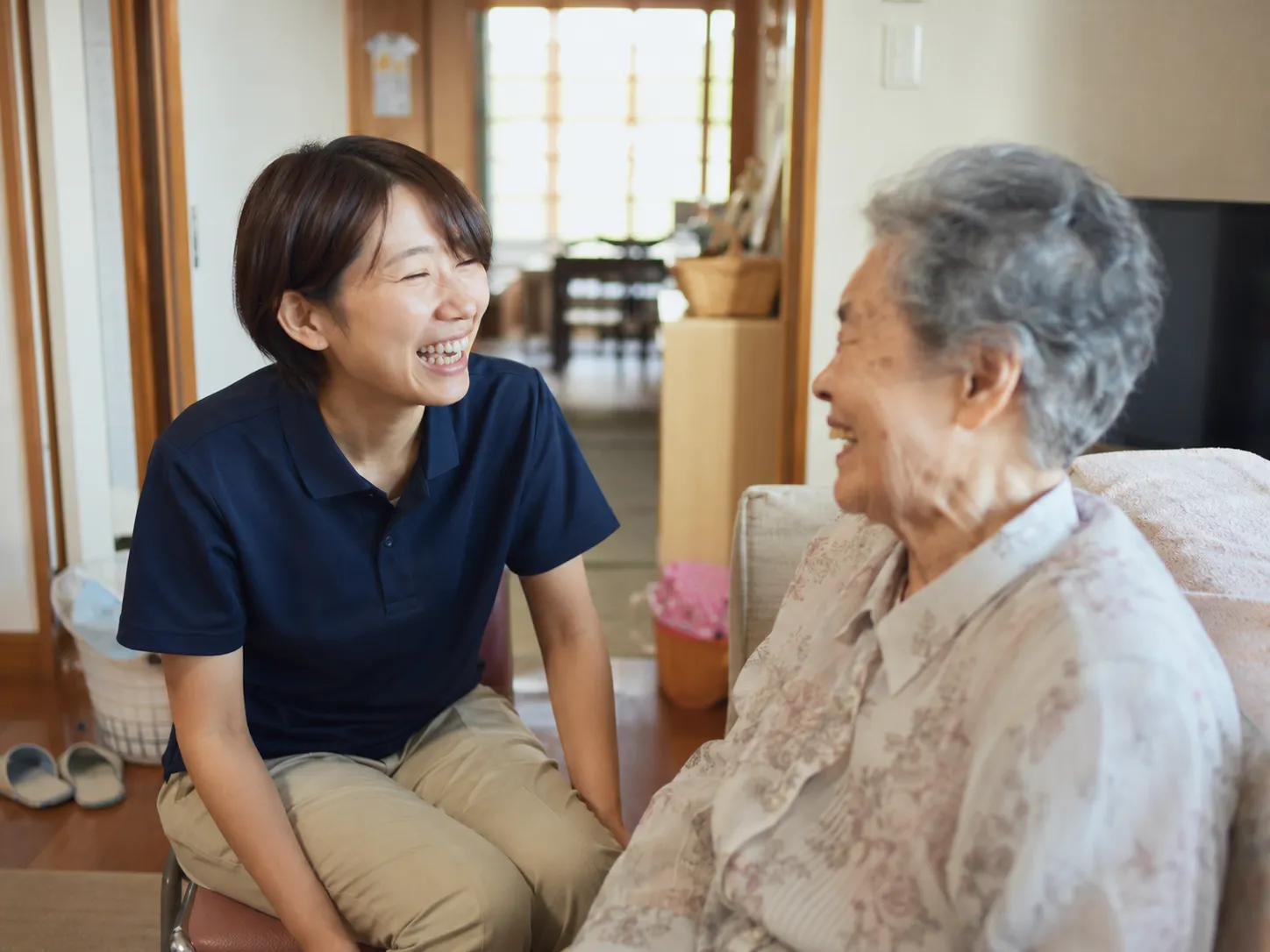 自宅で笑顔で話す看護師と利用者